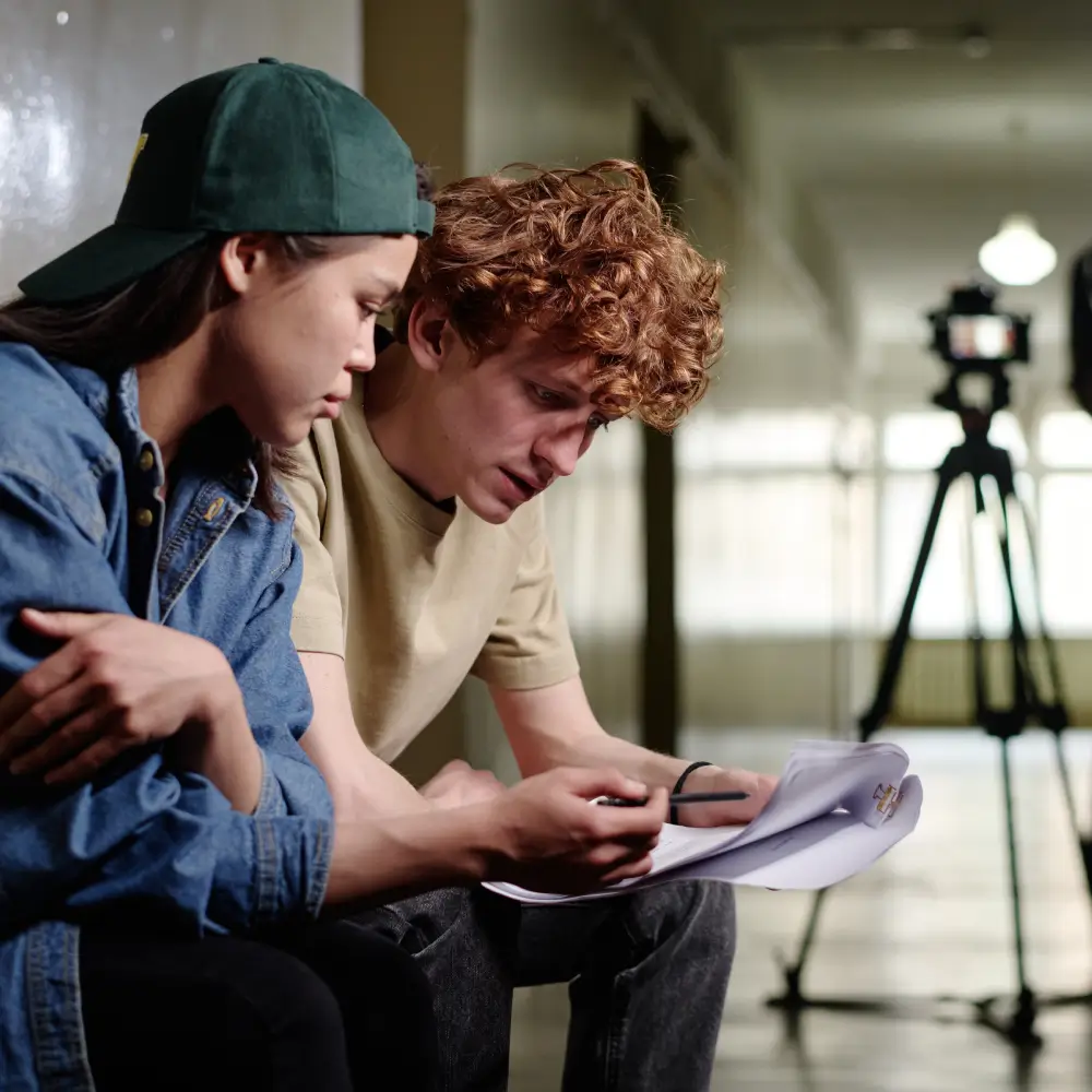Two young men reviewing notes in a film studio.